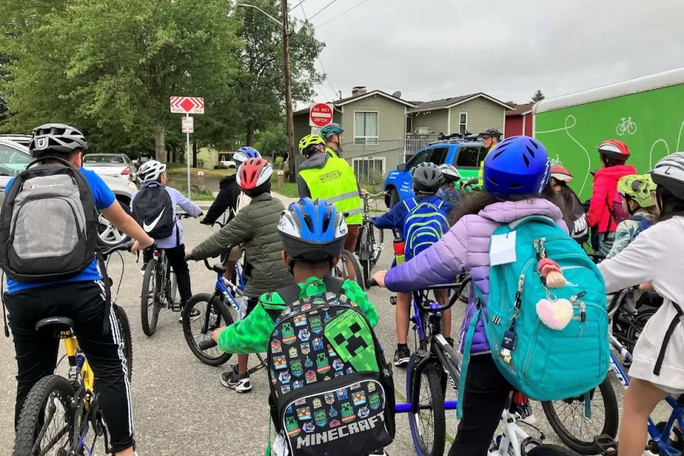 Group of children with backpacks and bike helmets going to school.